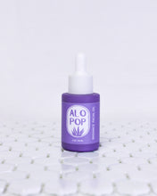 Load image into Gallery viewer, Glass Radiance Facial Oil bottle is sitting on white geometric tiles with a white background. The facial oil is in a muted lavender glass bottle with a matte finish. It has a white dropper top and a lavender label with white text on it. The text has the product title and the ALOPOP logo.