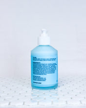 Load image into Gallery viewer, Glass bottle of Elderflower and Avocado Facial Moisturizer, creamy cyan blue lotion with a white pump top lid. Blue label with black text about usage, ingredients list and ALOPOP address. Acne friendly moisturizer is sitting on white geometric tiles with a white background.